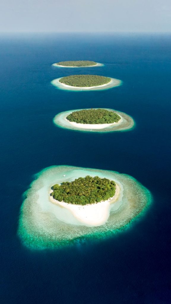 Aerial view of small Maldivian islands and surrounding reefs